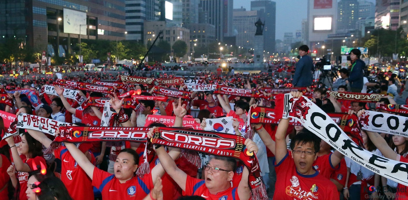 A packed stand of South Korea supporters waving Taegukgi flags