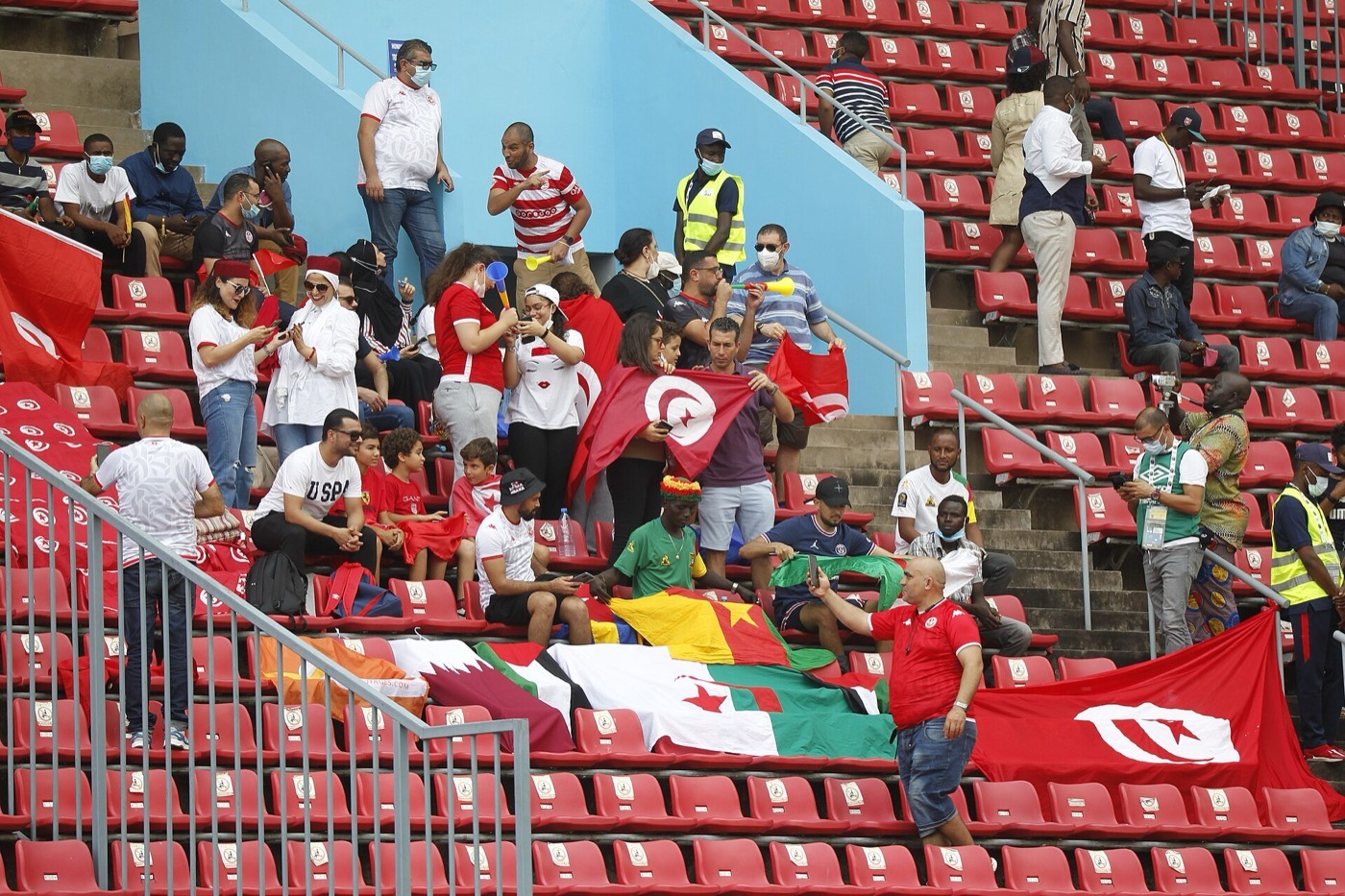 Tunisian fans packed into a stadium stand waving flags and banners